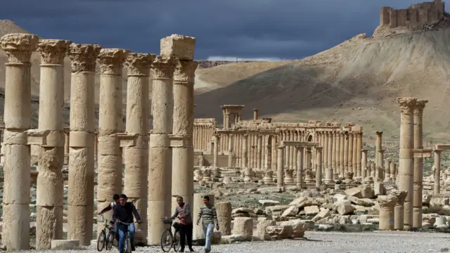 Foto yang diambil pada 14 Maret 2014 ini menunjukkan beberapa warga Suriah mengendarai sepeda melewati kota oase kuno, Palmyra. Turis terakhir mengunjungi kawasan ini pada September 2011, enam bulan setelah pergolakan terjadi di sana.