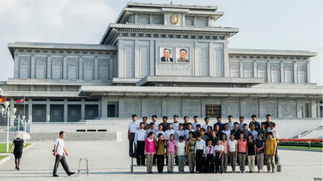 Orang-orang berfoto di depan kompleks makam Kim Il Sung dan Kim Jong Il di Istana Matahari Kumsusan pada 23 Agustus 2015 di Pyongyang, Korea Utara.