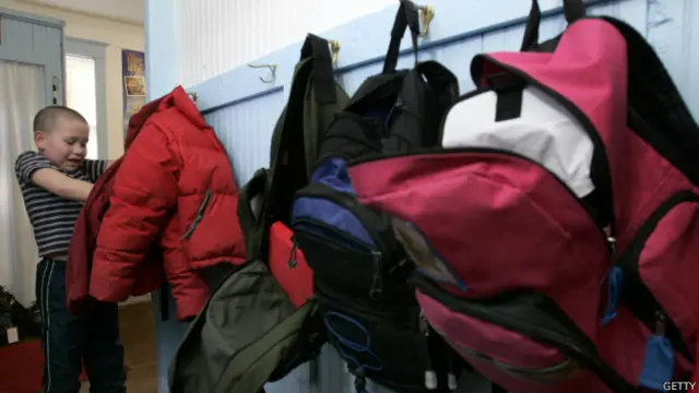 Школьник в раздевалке с рюкзаками