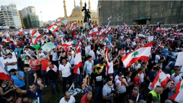 مظاہرین مرکزی بیروت کے بڑے چوک میں جمع ہیں، لبنان کے جھنڈے لہرا رہے ہیں اور حکومت کے خلاف نعرے بازی کر رہے ہیں