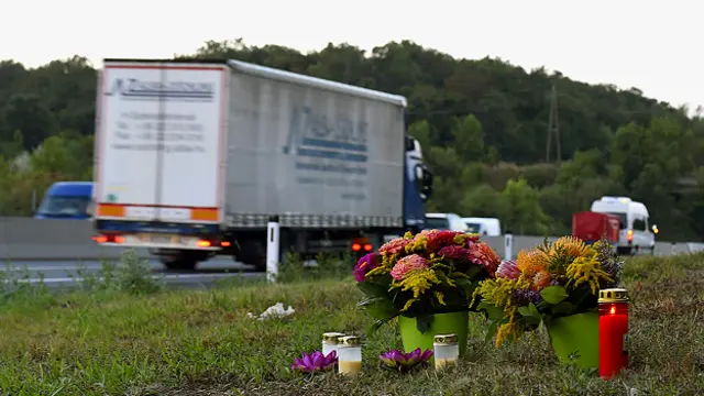 Цветы и свечи на месте обнаружения грузовика с погибшими
