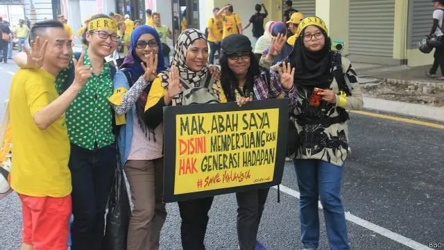 Masnah, 41, bersama pengunjukrasa lainnya tengah memegang poster dalam demonstrasi di Kuala Lumpur, Malaysia, Minggu (30/08). Dia menulis: "Mak, Abah, saya di sini memperjuangkan hak gerenasi hadapan #Savemalaysia