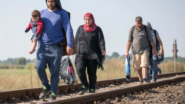 沿着赛尔维亚铁路跨越边境入境匈牙利的移民。