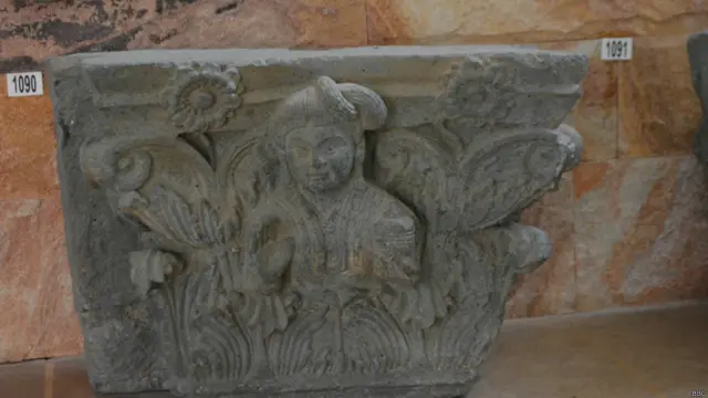 معلوم نہیں کیا وجہ ہے کہ یہاں اکثر بتوں کے چہرے مسخ ملے۔ یہ جان بوجھ کر کیے گئے یا کھدائی کے دوران ان کی یہ حالت ہوئی معلوم نہیں۔ لیکن پتھر کا یہ بت اس سے محفوظ رہا ہے۔