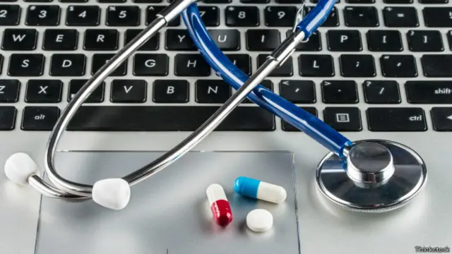 Estetoscopio y pastillas sobre un teclado de computadora