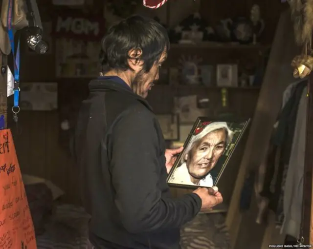 罗伯特拿着已故母亲的照片