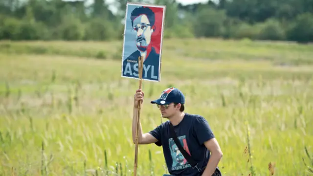 Una persona porta un cartel en apoyo a Edward Snowden