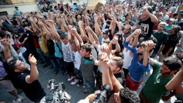 لاجئون سوريون وأفغان يحتجون للمطالبة بالذهاب إلى ألمانيا في محطة قطار في بودابست.