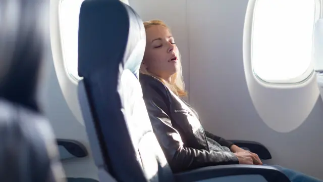 Una persona duerme en un avión