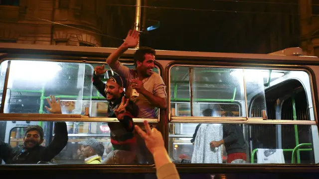 Seorang migran terlihat girang ketika bus yang membawanya mulai berangkat meninggalkan Hungaria untuk menuju Austria.