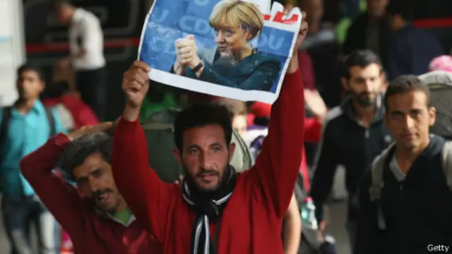 一些难民高举德国总理默克尔的大照片