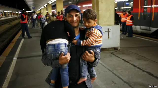 一名移民抱着孩子从维也纳火车站走出
