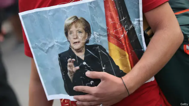 Một di dân từ Syria cầm theo ảnh của Thủ tướng Đức Angela Merkel hôm 5/9