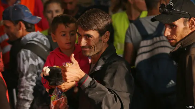 一名移民向迎接的人群竖起拇指