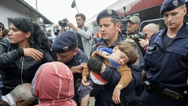 نیروهای پلیس اتریش به پناهجویان در سوار شدن به قطار کمک میکنند