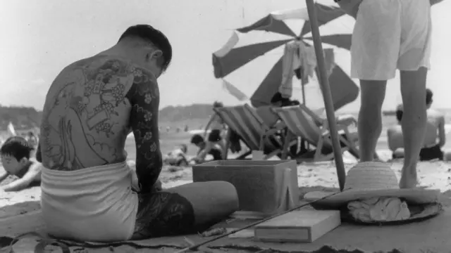 一名山口組成員在海灘上凖備釣魚用具（1955）