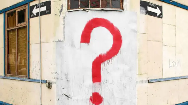 Un signo de interrogación en una pared