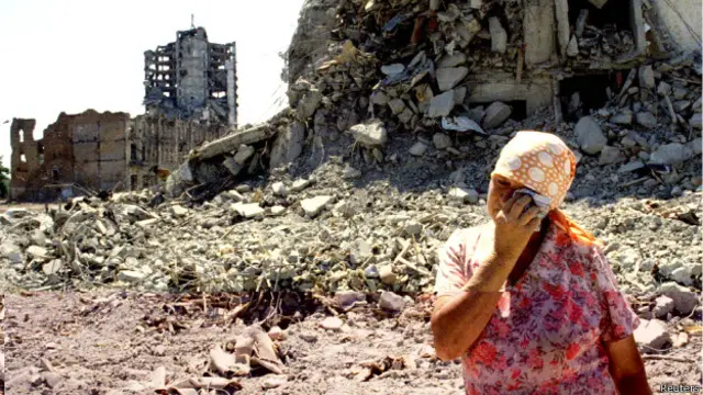 Жінка біля зруйнованих у Грозному будинків