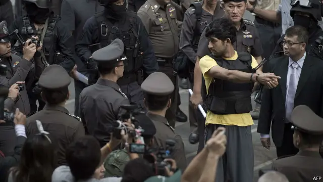 ဗုံးအိတ် လက်လွှဲပြောင်း ပေးခဲ့ပုံကို Yusufu Mieraili က ပြန် သရုပ်ဆောင် ပြခဲ့။