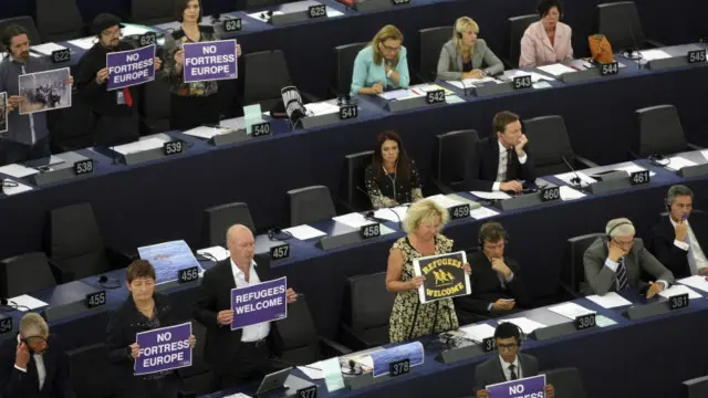 عده‌ای از نمایندگان پارلمان اروپا شعارهایی را در حمایت از پناهجویان در دست گرفتند