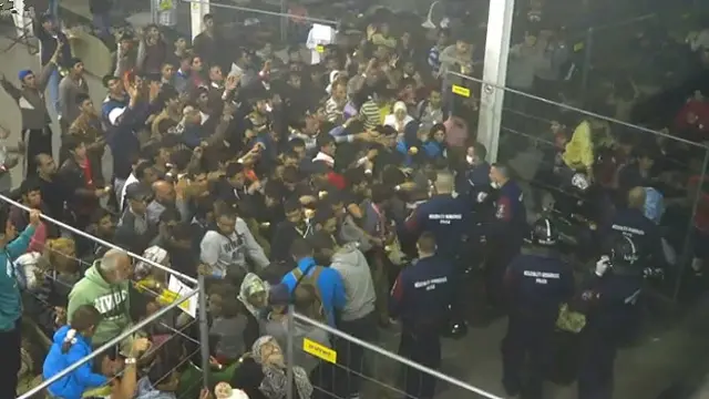 Miqrantlar polisin tulladığı ərzaq torbalarını tutmağa çalışır