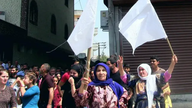 Sait Çağdavul'un cenazesini hastane morguna kaldıran kadınlar üzerlerine ateş edilmemesi için beyaz bayraklar taşıyor. 