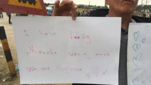 رجل سوري يحمل لافتة يعلن فيها عن امتنانه للمستشارة الألمانية أنجيلا ميركل