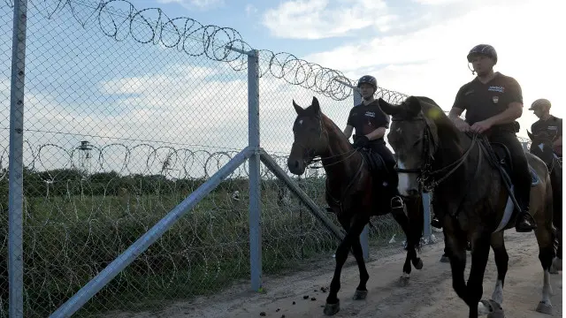 Polisi berkuda Hungaria berjaga di pagar yang baru dibangun untuk menangani pengungsi