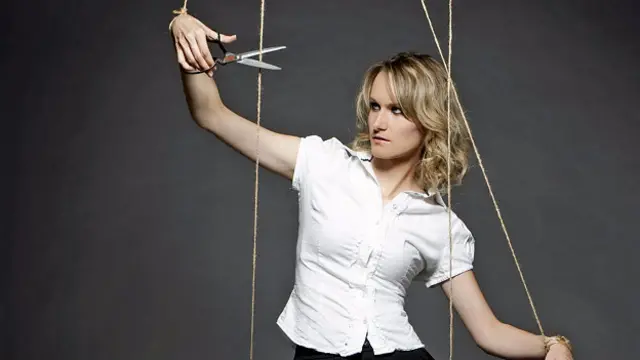 Девушка обрезает ниточки управления ею