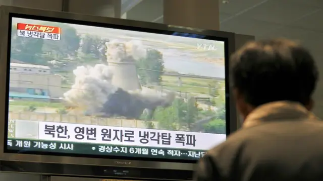 韩国民众观看朝鲜炸毁宁边核设施冷却塔的影片。