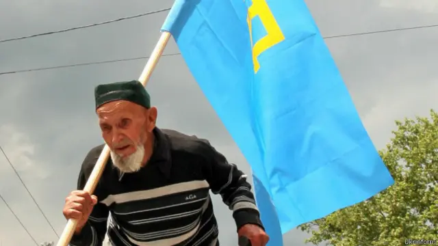 Старий чоловік, кримський татарин із національним прапором