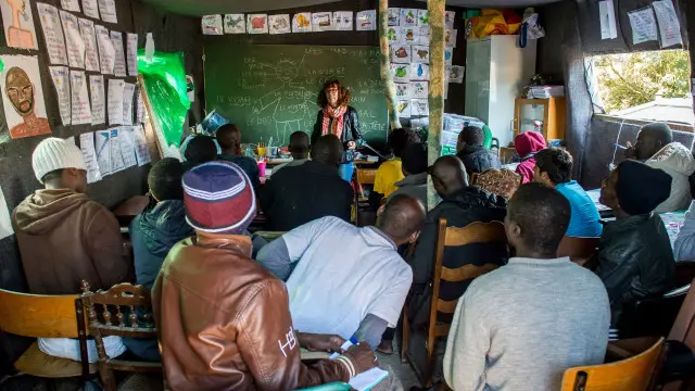 مهاجرون داخل مدرسة مؤقتة في مخيم كاليه.