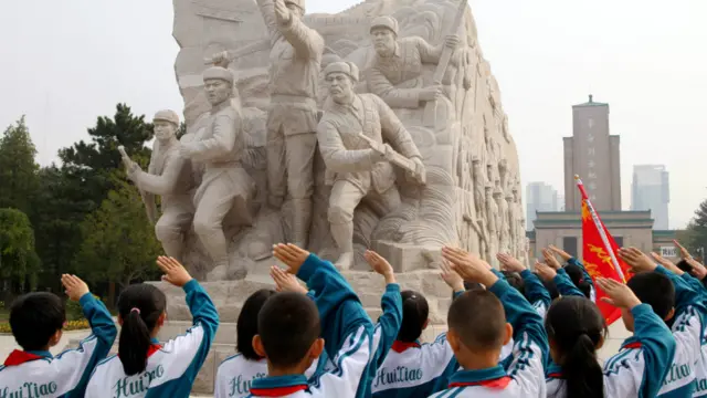 河北张家口的一所小学举行“铭记历史 勿忘九一八”祭扫活动，小学生向革命烈士雕像敬礼。