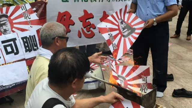 香港保钓人士日本领事馆附近的交易广场，焚烧军国主义太阳旗抗议。
