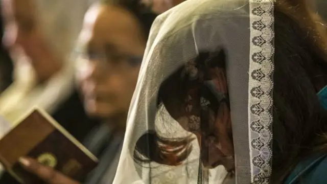Una mujer reza en un templo