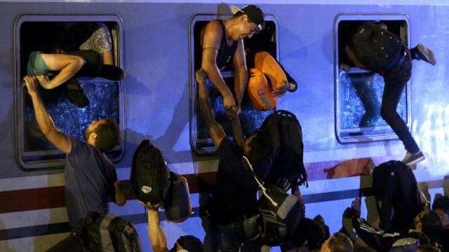 Мигранты залезают в поезд