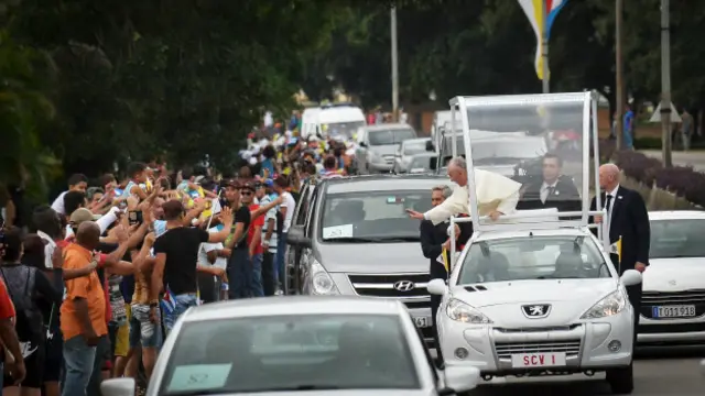 El papa se asoma hasta casi salirse del papamovil