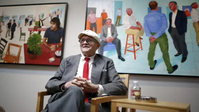 英國畫家大衛·霍克尼今年七月在自己的畫作前受訪。