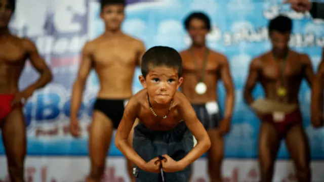 Niño haciendo pose de culturismo