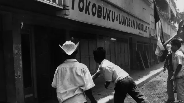 Sejumlah pemuda tengah berusaha merusak sebuah bangunan yang diduga milik anggota atau simpatisan PKI di Jakarta, 14 Oktober 1965.