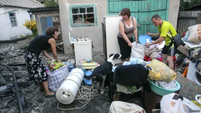 Мешканці Донбасу біля зруйнованого будинку 