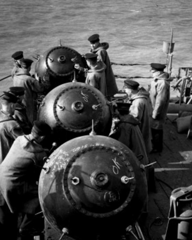 Efectivos de la Marina Real Británica colocan minas en posición para lanzarlas al agua.