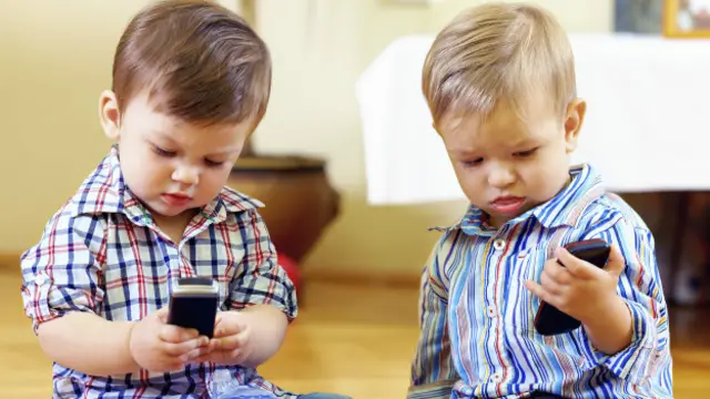 A los niños les encanta jugan con teléfonos móviles.