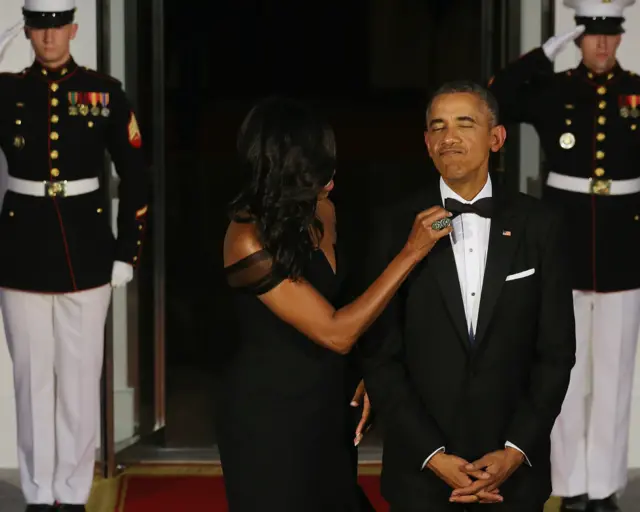 美國總統夫人米歇爾在國宴前為奧巴馬整理領結。