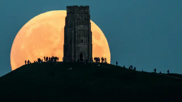 'Supermoon' terlihat di belakang Glastonbury Tor pada 27 September 2015 di Glastonbury, Inggris. 'Supermoon' terjadi karena Bulan berada dalam jarak terdekat dengan Bumi. 