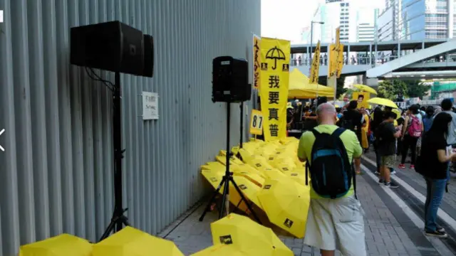 其中不少人手持象征“占中”运动的黄色雨伞及黄色横幅，也有人打出“我要真普选”的标语。