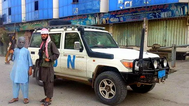 افراد مسلح طالبان در کنار خودرو سازمان ملل در قندوز. گزارش شده که این گروه دفتر سازمان ملل را آتش زده است