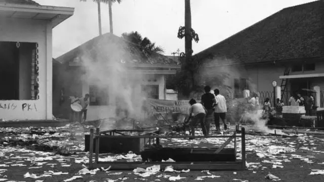 Massa membakar gedung milik salah satu organisasi PKI setelah peristiwa September 1965.