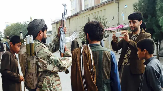 مواطنون يلتقطون صورا مع مقاتلي طالبان في قندز لدي سيطرتهم عليها العام الماضي