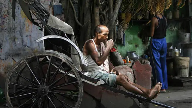 Индийский рикша пьет чай на городской улице